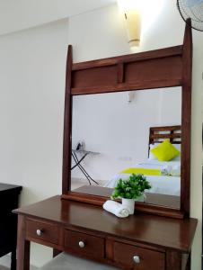 1 dormitorio con espejo en un tocador de madera en Lux Suites Diani Beachfront Studio Apartments, en Ukunda