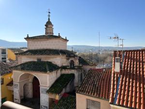 an old building with a tower on top of roofs at Con Alma in Plasencia