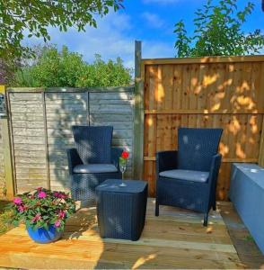 two chairs and a table on a patio at Private Lodge close to beaches and Goodwood in Felpham