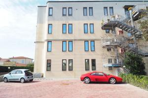 two cars parked in front of a building at L'incanto Di Boccadarno in Marina di Pisa