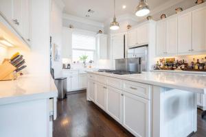 uma cozinha branca com armários brancos e um fogão forno superior em Beautiful upscale home near everything! em Houston