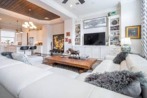 uma sala de estar com sofás brancos e uma televisão em Beautiful upscale home near everything! em Houston