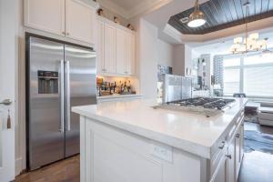 uma cozinha com um frigorífico de aço inoxidável e armários brancos em Beautiful upscale home near everything! em Houston