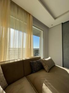 - un canapé dans une chambre avec une grande fenêtre dans l'établissement Shiny appartment in Prestigia, à Rabat