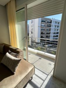 Shiny appartment in Prestigia في الرباط: غرفة معيشة مع أريكة ونافذة كبيرة