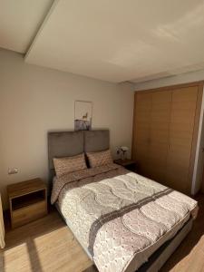Shiny appartment in Prestigia في الرباط: غرفة نوم مع سرير كبير وخزانة
