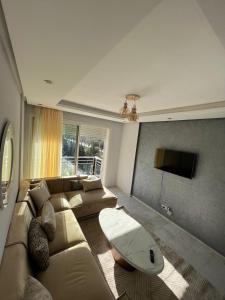 Shiny appartment in Prestigia في الرباط: غرفة معيشة مع أريكة وطاولة