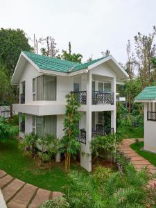 una casa con techo verde en The Woods Resorts Wayanad, en Sultan Bathery