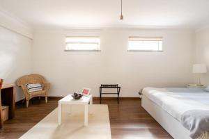 Dormitorio blanco con cama y mesa en Vinaika Loft, en Oeiras