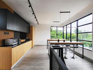 a kitchen with a table and some windows at Cabin15 - Syariah in Karangtengah