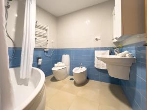 a bathroom with a sink and a toilet and a tub at Apartamentos Turísticos Con Alma in Plasencia