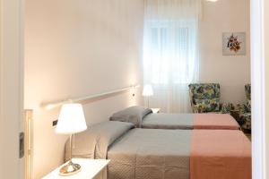 ein Hotelzimmer mit 2 Betten und einem Stuhl in der Unterkunft Charlotte appartamento, 5 Terre, Parcheggio vicino stazione in La Spezia