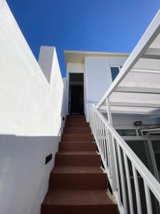 schody prowadzące do budynku z niebieskim niebem w obiekcie Juliet housing w Gżirze