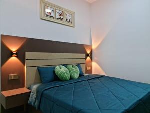um quarto com uma cama azul e 2 almofadas em RHR Deluxe GuestHouse Kinarut Papar Sabah - Pool View em Papar