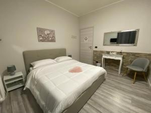 a bedroom with a bed and a table and a television at B&B Alpaca Biella in Biella