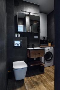ein Badezimmer mit einem WC, einem Waschbecken und einer Waschmaschine in der Unterkunft Apartament Monte in Sopot