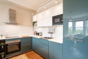 a kitchen with blue cabinets and a sink at Heritage Quarter in Fife