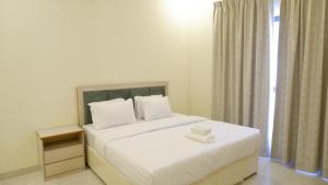 a white bed in a room with a window at Dar Al Seef Suites in Seef +8 photos
