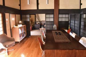 a living room with a large wooden table and chairs at sabouしが in Matsumoto