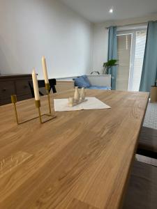 una mesa de madera con tres velas encima en SAND Apartment en Žilina
