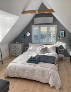 ein Schlafzimmer mit einem großen Bett im Dachgeschoss in der Unterkunft The Loft Hatch in Kent