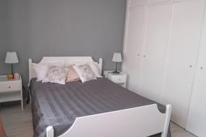 a white bedroom with a bed with two pillows at Beautiful and cozy flat close to beach and center in Lagos