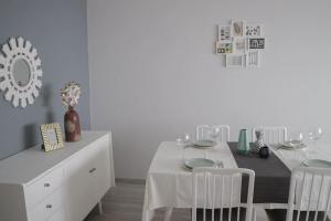 a white dining room with a white table and chairs at Beautiful and cozy flat close to beach and center in Lagos