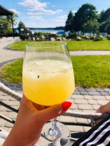 a person holding up a glass of orange juice at Ekosfera Piława Apartamenty z podgrzewanym basenem in Borne Sulinowo