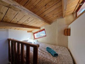 Cama en habitación con techo de madera en Le salagou sauna, en Lacoste