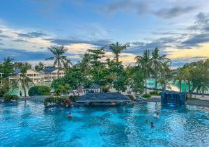 a pool at a resort with people in the water at Plantation Bay Resort and Spa in Mactan