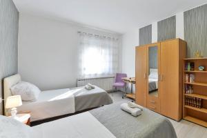 - une chambre avec 2 lits et une étagère dans l'établissement Apartmani Stadion, à Zadar