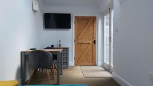 um quarto com uma secretária, um computador e uma porta em Peaceful Self-contained room near Looe em Looe