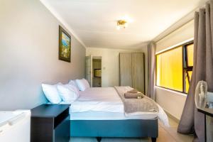 1 dormitorio con 1 cama y escritorio negro en Linden Guest House, en Johannesburgo