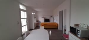 um quarto branco com um quarto com uma cama e janela em Maison ville agréable em Riorges