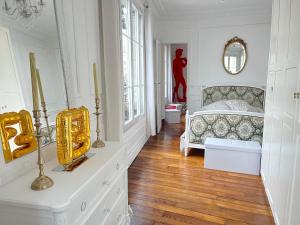 een slaapkamer met een bed en een dressoir met een spiegel bij Van Gogh's Apartment - Montmartre in Parijs