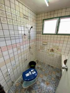 a bathroom with a blue toilet and a shower at Ratanawong Place 406 in Bangkok