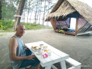 a man sitting at a table with a tray of food at Tammoyo Place in Kudat