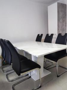 a conference room with a white table and black chairs at Messezimmer Hannover in Hannover