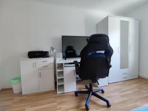 an office with a chair and a desk with a computer at Messezimmer Hannover in Hannover