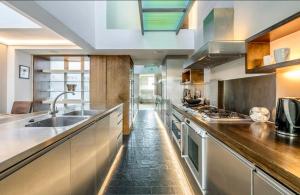 a large kitchen with a sink and a counter at Unique,architecturally acclaimed,Notting Hill home in London