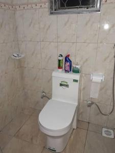 a bathroom with a white toilet in a room at Talpa Residences. in Tororo