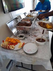 a buffet of food on a table with plates of food at Talpa Residences. in Tororo