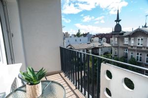 einen Balkon mit einem Tisch und Stadtblick in der Unterkunft Apartament Monte in Sopot