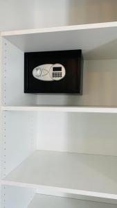 a microwave on top of a white shelf at LE VAISSEAU Maison avec piscine/parking/wifi/plages 5kms in Les Mathes