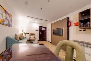 a living room with a table and a couch at Al Ertiqaa Hotel in Jeddah