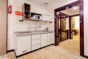 a kitchen with white cabinets and a counter top at Al Ertiqaa Hotel in Jeddah