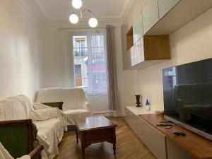 a living room with a television and a couch and a table at Beau 3 pièces à Paris 13 in Paris