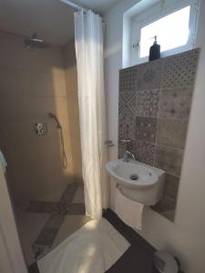 a bathroom with a sink and a toilet and a shower at Gîte des Frangines in Beaumont