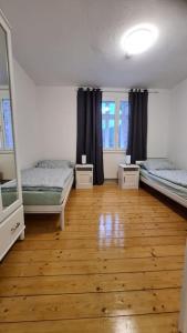 a room with two beds and a wooden floor at Großzügige Wohnung auf dem Hof Historischen Mühle in Holzhausen