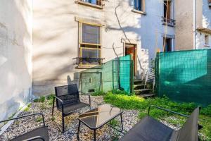patio z krzesłami i stołem przed budynkiem w obiekcie Cénoslocs Bondy - Paris à vos pieds pour 4 personnes avec Jardin & Wifi w mieście Bondy